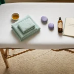 Massage a domicile : table de massage prête, huiles et pierres